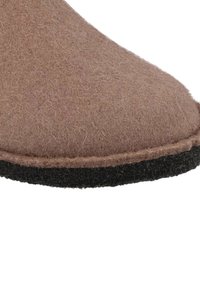 Bruine vilten slipper met een afgeronde teen, zwarte rubberen zool en een gestikte naad langs de bovenrand. Zachte textuur en minimalistisch ontwerp.