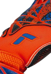 Oranger Sporthandschuh mit strukturierten schwarzen und blauen Akzenten, ausgestattet mit einem blauen Logo und passgenauem Handgelenkverschluss. Hergestellt aus flexiblem synthetischem Material.
