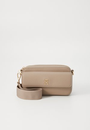 Bolso cruzado de cuero sintético beige con herrajes dorados, cierre de cremallera y una correa de tela desmontable que presenta un logotipo en la parte frontal.