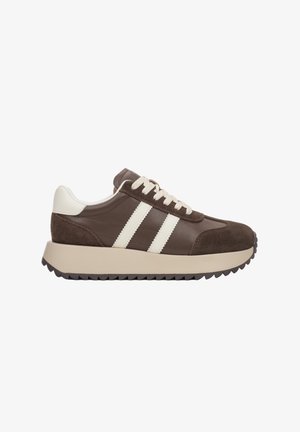 Brązowe skórzane i zamszowe sneakersy z białymi paskami, okrągłym czubkiem, teksturowaną podeszwą, sznurowanym przodem i kremowymi akcentami.