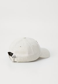 Casquette gris clair en tissu texturé avec un visière incurvée, une sangle ajustable à l'arrière et des œillets de ventilation pour une meilleure respirabilité.