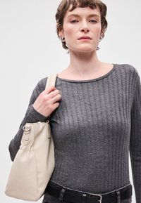 Γκρι ριγωτό μακρυμάνικο μπλουζάκι με φαρδύ λαιμό, συνδυασμένο με μία απαλή εκρού τσάντα tote με συγκεντρωμένο σχέδιο και ασημένια αξεσουάρ.