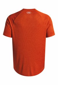 Camiseta atlética roja de manga corta con cuello redondo, tejido texturizado y un pequeño logo en la parte posterior cerca del cuello.