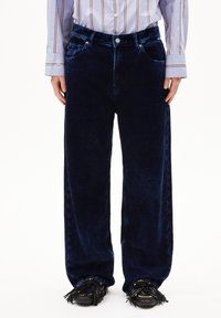 Marinblå sidennötsbyxor med vid benvidd och texturerad yta, med framfickor, knäppning och bälteshällor för justering.