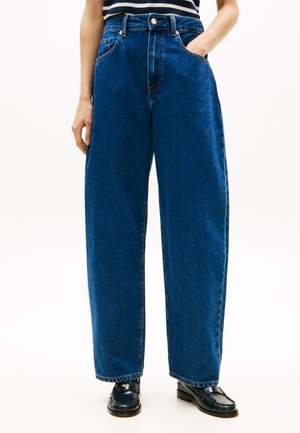 Jean large taille haute en denim bleu foncé avec une texture lisse, doté de poches avant et d'une fermeture classique à boutons.
