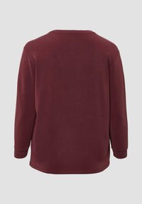 Bordowy top z długim rękawem, okrągłym dekoltem, prostym krojem i prążkowanymi mankietami. Gładka faktura z minimalnymi detalami na plecach.