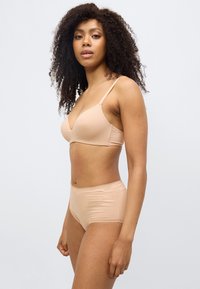 Ανοιχτό μπεζ σουτιέν και παντελόνι μεγάλου ύψους από λείο ύφασμα, με λεπτές τιράντες και δαντέλα στο τελείωμα. Απλός, χωρίς ραφές σχεδιασμός με φυσική εφαρμογή.