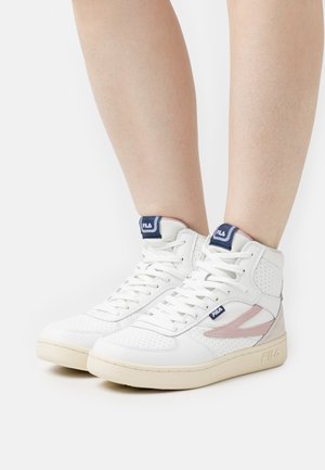 Sneakers alte bianche in pelle perforata, con dettagli rosa e suola in gomma color marrone. Presentano lacci e un logo blu sulla linguetta.