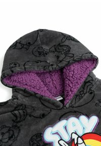 Felpa grigia con cappuccio, foderata in pile viola, con grafica nera in stile cartoon e una stampa colorata "STAY" sul davanti. Tessuto morbido.