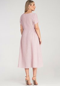 Helles pinkes Leinenkleid mit kurzen Ärmeln, lockerem Schnitt und gerafftem Seitendetail. Das Design verfügt über einen knielangen Saum und eine glatte Textur.