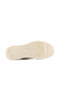 Suola delle scarpe in gomma beige con un motivo di presa texturizzato. Presenta design circolari e angolari per la trazione. Superficie liscia con una leggera lucentezza.