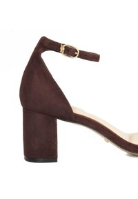 Brown suede block-heel sandal with an adjustable ankle strap and a gold-tone buckle. Smooth beige insole with a slight curve.