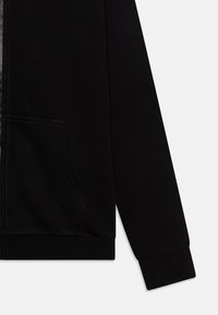 Sudadera con capucha negra con cremallera, fabricada con tela suave, que incluye un bolsillo frontal, puños acanalados y una cremallera lisa. Diseño sencillo y funcional.