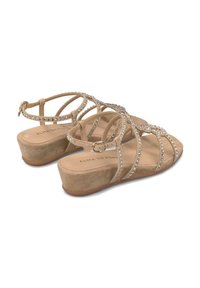 Sandali con zeppa beige decorati con strass luccicanti, cinturini in scamosciato e una soletta imbottita. Chiusura con fibbia su cinturino alla caviglia regolabile.