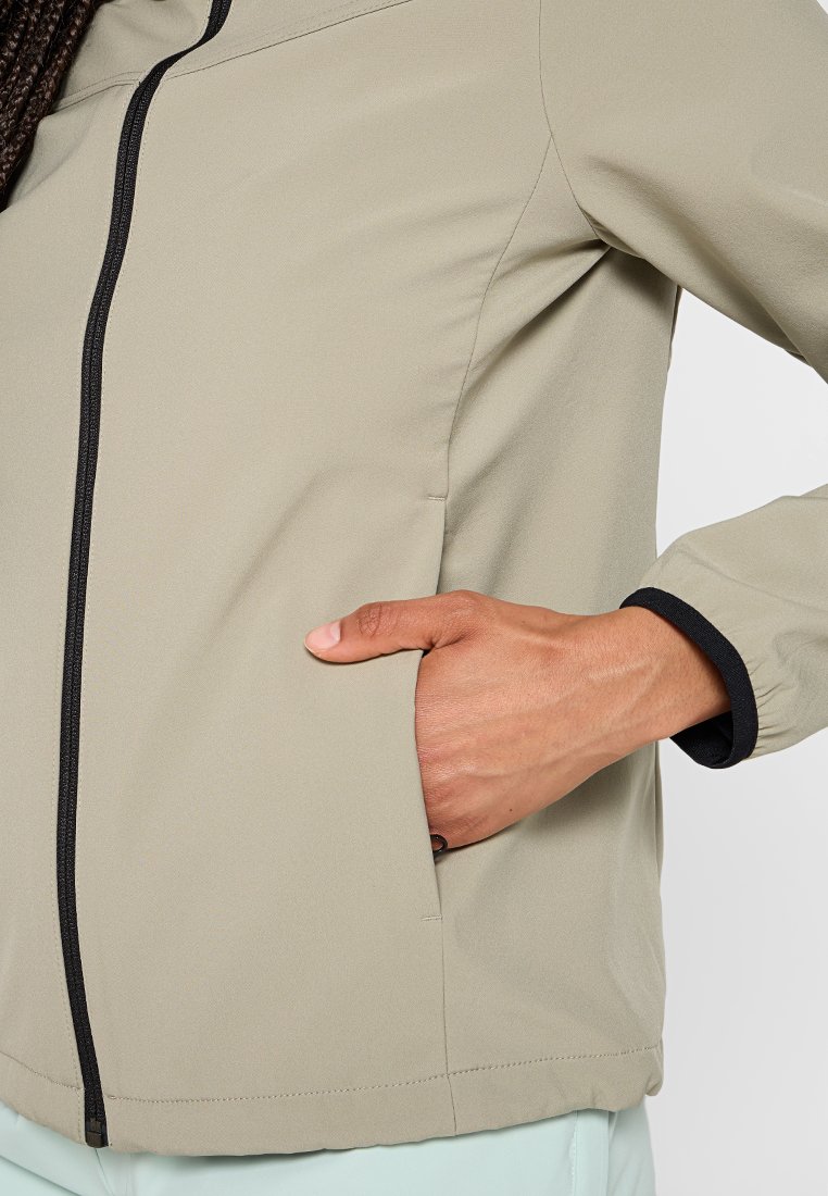 Giacca color beige chiaro con zip frontale e dettagli neri lungo il colletto e i polsini. Include tasche laterali per una comoda conservazione.