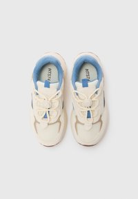 Lys beigefargede sneakers med blå detaljer, mesh og teksturert stoff, runde lisser med en strammemekanisme, gummisåler og logo på tungen.
