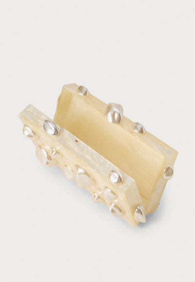 O poșetă rectangulară din material translucid de fildeș, având țepi metalici argintii pe margini pentru un plus de textură și detaliu.