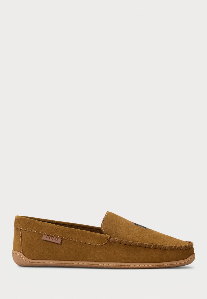 Pantofole moffate in suede marrone con dettagli cuciti, suola beige e un piccolo cartellino in pelle con l'etichetta "Polo" sul lato.