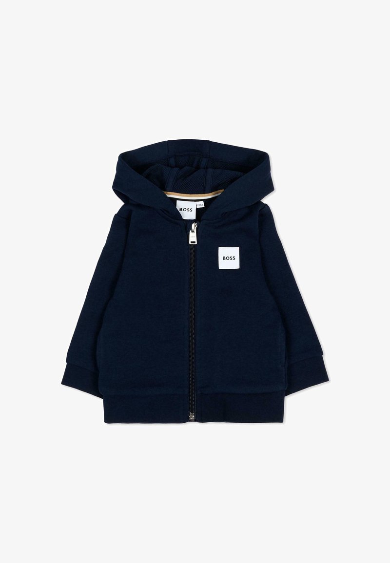 Felpa con cappuccio da bambino color blu navy con zip e una toppa quadrata bianca con la scritta "BOSS" sul petto.