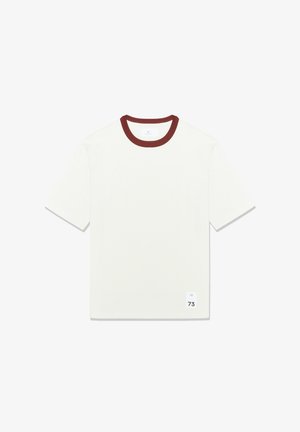 Bijela kratka majica s kratkim rukavima i bordo rebrastim okovratnikom, s kvadratnom etiketom sa slovom 'M' i brojem '73' na donjoj lijevoj strani.