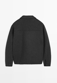 Donkergrijze wollen jas met een knoopmanchet, klassieke kraag en een gladde textuur. Heeft een naad over de bovenrug.