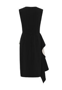Robe noire sans manches longueur genou avec un détail asymétrique de volants blancs sur le côté droit et une fermeture éclair à l'arrière.