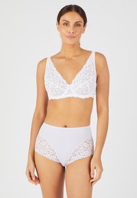 Witte kant bralette met V-hals en geschulpte randen, gecombineerd met hoge witte slipjes met kanten zijkanten. Glad textuur.