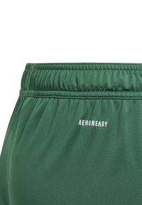 Tumed rohelised lühikesed püksid, millel on kogutud kummivöö ja valge "AEROREADY" logo, valmistatud niiskust eemal hoidvast materjalist.