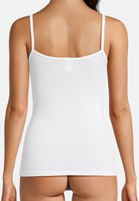 White tank top with thin straps, made from smooth cotton fabric. Features a rounded neckline and a fitted design, exposing the back.