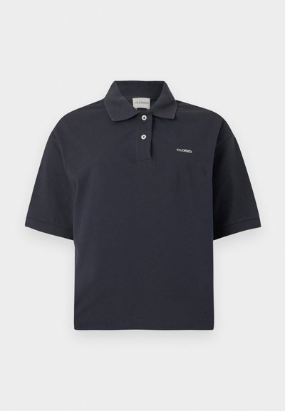 Σκούρο μπλε κοντομάνικο πόλο πουκάμισο με δύο κουμπιά και μικρό λευκό λογότυπο "CLOSED" στο στήθος και ετικέτα για το γιακά.