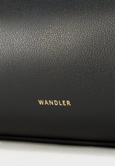 Μαύρο δερμάτινο αντικείμενο με υφή στην επιφάνεια και ανάγλυφο χρυσό λογότυπο "WANDLER". Λείο φινίρισμα με διακριτική λάμψη. Δεν διακρίνονται επιπλέον διακοσμητικά στοιχεία.