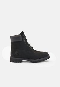 Botín negro de cuero con cordones, con cuello acolchado y suela resistente, logo de Timberland en relieve en el lado del talón.