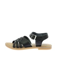 Sandale en cuir noir avec des sangles tissées, une boucle réglable et une semelle plate. L'intérieur présente une doublure beige et des bords piqués.