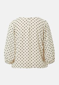 Cremefarbene Bluse mit schwarzen Pünktchen, mit Puffärmeln und einer Knopfleiste hinten. Weicher Stoff mit glatter Textur.