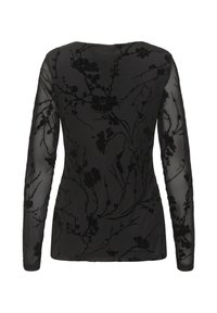 Sort langærmet top med en gennemsigtig overlay, som har et indviklet blomstermønster i mørkere nuancer af sort og teksturerede detaljer. Rund halsudskæring.