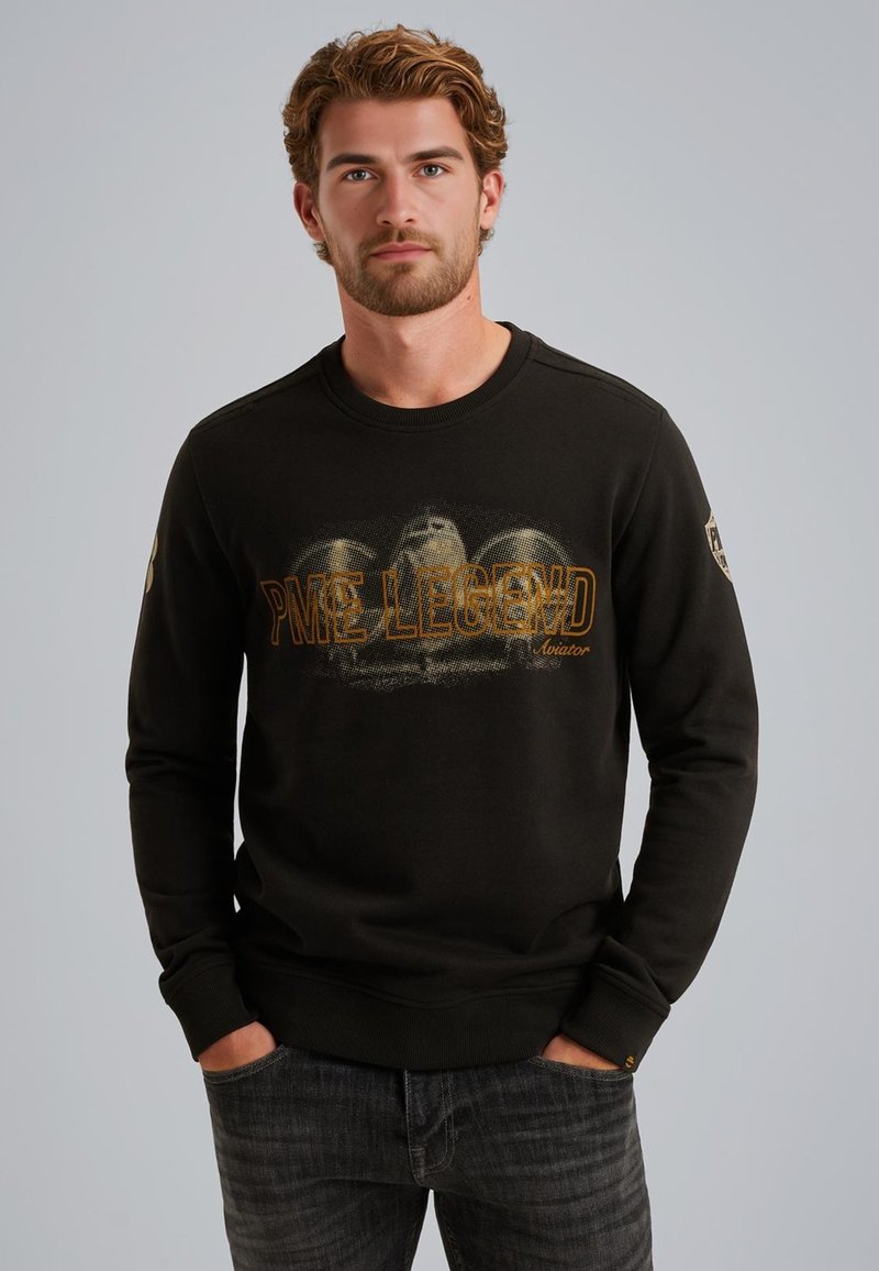 Sudadera negra con cuello redondo, que presenta "PME LEGEND Aviator" en texto naranja en la parte frontal y elementos gráficos en relieve de color gris.