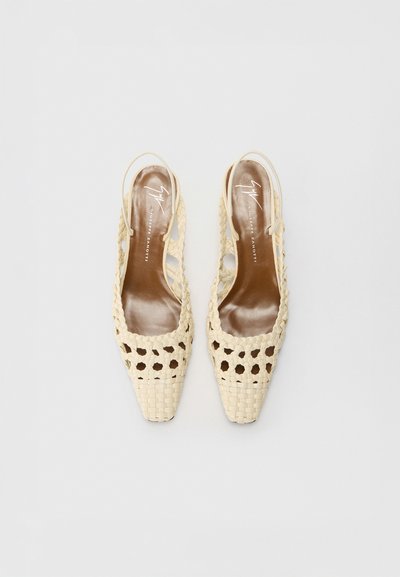 Tacones de esparto en color beige con diseño de tiras, con puntera cuadrada, que presentan un diseño cortado y una plantilla marrón suave. Acentuados con un logo en la plantilla.