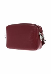 Sacoche en cuir rouge foncé compact avec deux compartiments zippés et quincaillerie en métal argenté sur fond blanc.