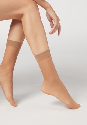 Calcetines tobilleros nude fabricados con material transparente, con un puño sólido y elástico y una textura suave, con los dedos de los pies al aire y un diseño sin costuras.