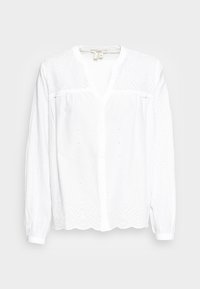 Weiße Bluse mit V-Ausschnitt, Knopfleiste, langen Ärmeln, Stickdetails aus Augenlöchern und gewelltem Saum. Leichtes Material.