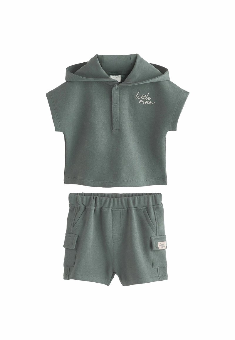Graues Zweiteiler-Outfit mit einem Kurzarm-Polohemd, das über eine Kapuze und Knöpfe verfügt, kombiniert mit Shorts mit elastischem Bund und seitlichen Taschen.