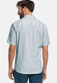  Lichtblauw overhemd met korte mouwen en een kraag, gemaakt van een gestructureerde stof met een subtiel patroon en zichtbare naaddetails op de achterkant.