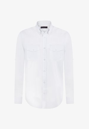 Camisa blanca de botones con mangas largas, dos bolsillos en el pecho y un cuello. Hecha de tejido ligero con una textura sutil.
