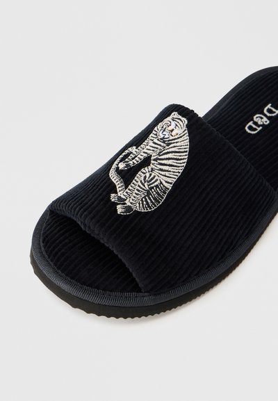 Μαύρο σανδάλι slide από κοτλέ με κεντητό σχέδιο τίγρης στην επάνω επιφάνεια. Στυλ με ανοιχτά δάχτυλα, υφή στην επιφάνεια και λαστιχέν ια σόλα.