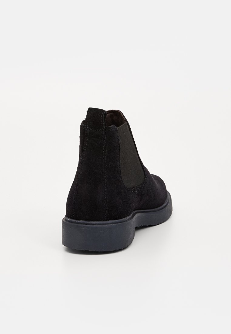 Bottines Chelsea en suede noir avec panneaux élastiques, bout rond et semelle en caoutchouc texturé. Design minimaliste et col rembourré pour le confort.