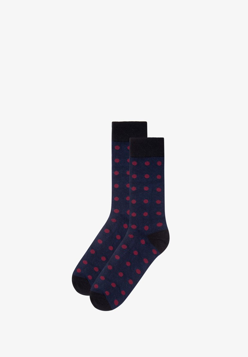Marineblaue Socken mit dunkelroten Punkten, schwarzen Bündchen, Fersen und Spitzen, flach nebeneinander auf weißem Hintergrund ausgelegt.