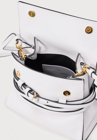 Λευκή δερμάτινη τσάντα χιαστί με χρυσούς κλειστές και μαύρη εσωτερική επένδυση, ανοιχτό καπάκι που αποκαλύπτει εσωτερική τσέπη και αποσπώμενο λουράκι.