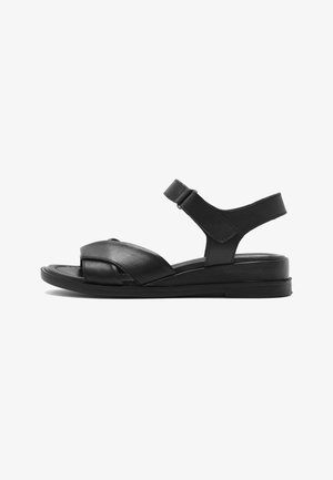 Black leather flat sandal with adjustable ankle strap and crisscross front straps on a low sole.