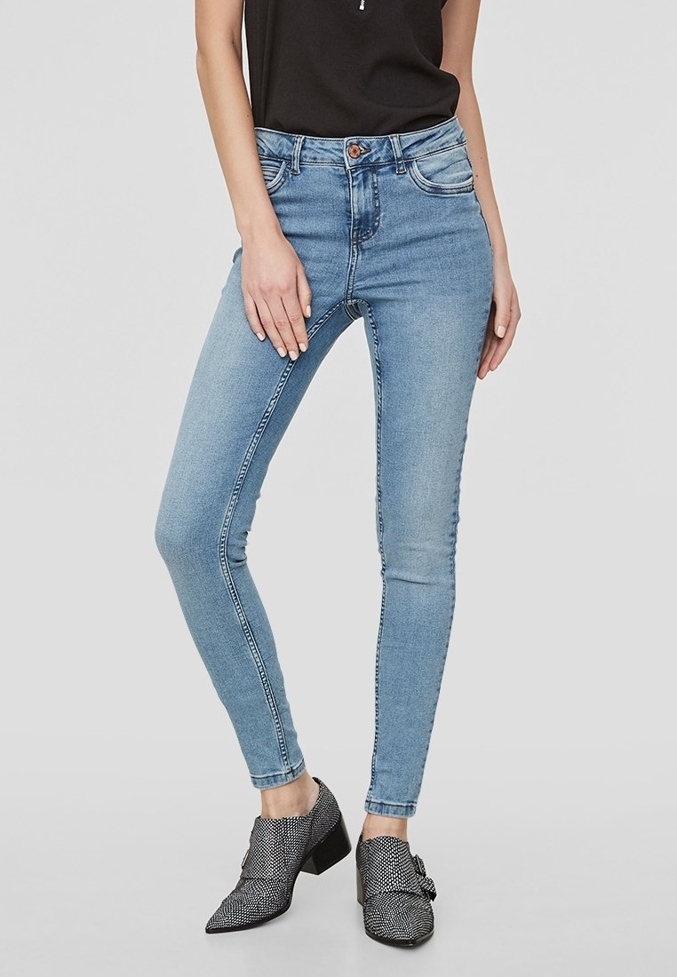 Wąskie dżinsy z jasnoniebieskiego denimu z pasem o średnim stanie, z delikatnym wyblaknięciem, kontrastującymi przeszyciami i zamkniętym suwakiem.