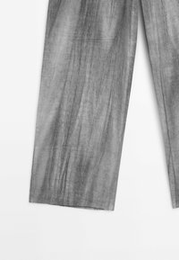 Pantalons larges en lin gris avec une finition texturée. Présentent une coupe décontractée, des plis visibles et un design simple, sans ornement.